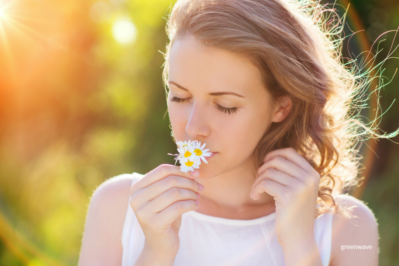 Attractive young woman with flowers outside on a meadow.
